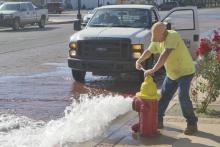 (ARCHIVE PHOTO | THE GRAHAM LEADER) City of Graham crews open a hydrant near Oak Street and Second Street in Graham. The city will be ‘flushing’ lines and temporarily converting the disinfectant from chloramine to free chlorine starting next week.
