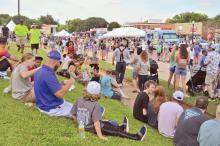 (FILE PHOTO | THE GRAHAM LEADER) Visitors to the 2022 Food Truck Championship of Texas sit down to enjoy a bite from one of over 35 food trucks which were present at the event on the Graham downtown square. The event this year will be held Saturday, June 3, starting at 11 a.m. on the downtown square.