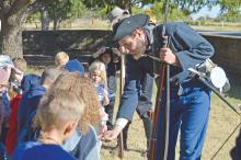 (FILE PHOTO | THE GRAHAM LEADER) Reenactment soldiers show off to Open Door Christian School students what is used in the rifles used for Fort Belknap Days. The living history event is returning next weekend with a public event scheduled for Saturday, Oct. 28.
