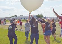 (ARCHIVE PHOTO | THE GRAHAM LEADER) Students of Open Door Christian School and Stem Director Claire Meschkat walk a weather balloon to a launch site at Graham Municipal Airport in 2021. Another launch is planned for May at the airport.