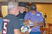 (ARCHIVE PHOTO | THE GRAHAM LEADER) Former Dallas Cowboys player Randy White signs a football at the Graham Regional Medical Center auction fundraiser held in September 2022 at the Wildcatter Ranch & Resort in Graham.