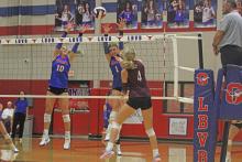 (ALEX HAVARDANKSY | THE GRAHAM LEADER) Emily Hughes, 10, and Katy McGehee, 1, team up for a block attempt in one of their matches. The Lady Blues lost to the Honeybees in four sets Tuesday, Sept. 30.