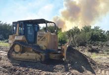 (CONTRIBUTED PHOTO | TEXAS A&M FOREST SERVICE) A dozer creates a suppression line in the early stages of the Storage Fire which began Wednesday, June 28 at Possum Kingdom Lake. The fire was determined by Texas A&M Forest Service to be 100% contained this week.