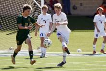 (KYLIE BAILEY | THE GRAHAM LEADER) Steer Jacob Collins (12) kicks the ball away during the bi-district matchup with Cooper Wilde (17) watching from behind. The Steers fell 3-0 in the game Friday, March 20 in Canyon.