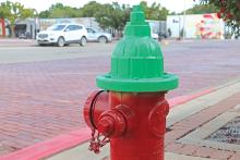 (THOMAS WALLNER | THE GRAHAM LEADER) A green hydrant located on Oak Street on the Graham downtown square which represents a water flow of 1,000 to 1,499 Gallons Per Minute. There are a total of 28 green hydrants around the city of the 335 total, or 8%.