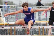 (TC GORDON | THE GRAHAM LEADER) Graham’s Zathin Reyes leaps over a hurdle during one of the two hurdle events the senior competed in at a meet Thursday, March 7 in Comanche.