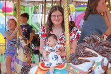 (ARCHIVE PHOTO | THE GRAHAM LEADER) Visitors to the Graham Lions Club Carnival in 2024 ride the merry-go-round on the downtown square. The carnival will be held in the same location May 7-10 opening each day at 5:30 p.m.