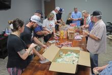 (THOMAS WALLNER | THE GRAHAM LEADER) Volunteers and members of American Legion Post 34 make care packages for U.S. Marines in four locations across the globe. Some the locations the care packages will be sent include Japan and Spain.