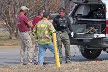 (THOMAS WALLNER | THE GRAHAM LEADER) A member of the Denton Fire Department bomb disposal team speaks with members of Texas Division of Emergency Management near the Gateway Inn where an explosive device was located Friday, Feb. 13.