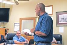 (ARCHIVE PHOTO | THE GRAHAM LEADER) Texas Department of Transportation Area Engineer Zach Husen (right) presents information to the Young County Commissioners Court during their meeting Monday, June 10. Husen spoke to the commissioners about a national grant to aid in roads and bridges improvement projects.