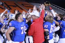 (TC GORDON | THE GRAHAM LEADER) Graham High School head football coach Kenny Davidson presents the bi-district championship trophy to his team Friday, Nov. 10 after the Steers defeated the Hillsboro Eagles 56-0. Davidson will be retiring after 19 years with the district.