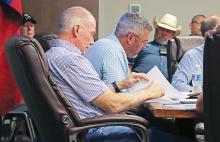 (THOMAS WALLNER | THE GRAHAM LEADER) Graham City Council member Jeff Dickinson and Mayor Alex Heartfield look over documents provided by City Manager Eric Garretty during a budget workshop Aug. 7, 2025. The city approved raising the water and sewer rates during the meeting and will consider another increase this year.