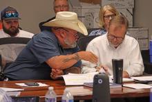 (ARCHIVE PHOTO | THE GRAHAM LEADER) City Manager Eric Garretty (right) and Animal Control Officer Mike Watts look over documents during a meeting of the Graham City Council in 2025. The city council approved Garretty to renegotiate the rate structure to $500 per animal with the Humane Society of Young County.