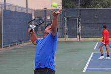 (ALEX HAVARDANKSY | THE GRAHAM LEADER) Chris Reyes throws a ball up in the air for a serve attempt during one of his matches. Reyes was named an academic all-district player for the boys tennis team. 