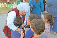 (ARCHIVE PHOTO | THE GRAHAM LEADER) Mary Braddock hugs children who came up to talk ‘Mrs. Cookie’ during the Cookie Day event in 2023. Braddock and her family have kept up the tradition for over 60 years.