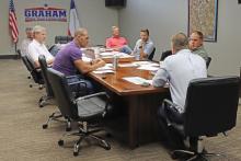 (THOMAS WALLNER | THE GRAHAM LEADER) The Graham Economic Improvement Corporation Board of Directors hears a report from Graham City Manager Eric Garretty regarding housing initiatives. The city manager said the GEIC housing incentive program has worked to attract new developers to Graham.