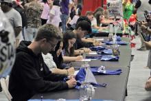 (ALEX HAVARDANSKY | THE GRAHAM LEADER) Students sign their offers to various schools at the Graham High School signing day ceremony Monday, May 12. 