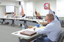 (THOMAS WALLNER | THE GRAHAM LEADER) Members of the Graham ISD Board of Trustees raise their hands to approve the contract for Dr. Mary Johnston as the new superintendent for the district. The board named Johnston as the lone finalist Wednesday, Oct. 23 during a special-called meeting.