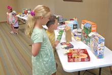 (THOMAS WALLNER | THE GRAHAM LEADER) Children in the Library of Graham's summer reading program look over some of the 30 prizes which were available for those who read 30 minutes a day for six weeks. The program held its finale Wednesday, June 26 at the library.