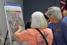 (THOMAS WALLNER | THE GRAHAM LEADER) Two residents of Graham look at a map showing the pavement conditions assessments results. According to the study, nearly half the streets are classified as needing proactive maintenance or rehabilitation.