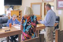 (TC GORDON | THE GRAHAM LEADER) Justin Gilmore of Level 5 Architecture (right) presents the only bid the county received for renovation work of the former tax assessor-collector’s office at commissioners court Monday, Aug. 26. The project will be on hold as the only bid came in higher than anticipated and commissioners want to evaluate if it can be lowered.