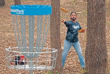 (THOMAS WALLNER | THE GRAHAM LEADER) A participant in the ninth annual Toys for Tots Doubles Tournament from the Graham Disc Golf Club lines up a shot between two trees. The tournament was held Saturday, Dec. 7 benefiting Young County Toys for Tots. 