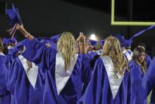 (THOMAS WALLNER | THE GRAHAM LEADER) Two students hold hands while saying goodbye to their high school years at the conclusion of the Graham High School Class of 2025 graduation ceremony Friday, May 23.