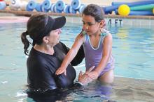 (THOMAS WALLNER | THE GRAHAM LEADER) Tracey Terasas speaks with a preschool student from Pioneer Elementary School during a swim boot camp held this week at the Graham Regional Medical Center Wellness Center.