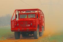 (THOMAS WALLNER | THE GRAHAM LEADER) A Murray Volunteer Fire Department brush truck arrives Friday, March 14 to assist other county volunteer fire units fight a grass fire near the transmission lines off of Fish Creek Road. Dust and smoke filled the air as volunteers units fought gusts of wind. 