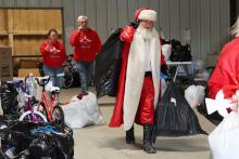 (THOMAS WALLNER | THE GRAHAM LEADER) Santa himself delivers presents to Angel Tree families during the Lions Club of Graham Angel Tree distribution day held Friday, Dec. 19. Each angel also received a hygiene bag from the club that covered enough items for each child in the family.
