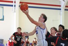 (THOMAS WALLNER | THE GRAHAM LEADER) Ty Thompson jumps over Levelland players Saturday, Dec. 14 to score a layup during crossover play of the Red, White & Blue Tournament in Graham.