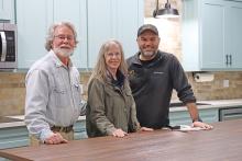 (THOMAS WALLNER | THE GRAHAM LEADER) Dennis and Andy Heath sit behind a counter with The Arc of Wichita County Executive Director Anthony Watkins (right) at the Hero House. The renovated kitchen area is one of the features of the Intellectual and Developmental Disabilities day habilitation facility.