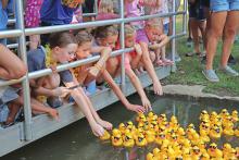 (ARCHIVE PHOTO | THE GRAHAM LEADER) Visitors to the Rotary Club of Graham Duck Derby touch a small portion of the 10,000 rubber ducks that were raced from one side of the pond at Firemen’s Park to Salt Creek. The event this year will be held Saturday, Oct. 19.