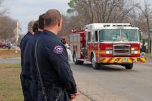 (THOMAS WALLNER | THE GRAHAM LEADER) Members of Graham Fire Department watch an escort for former fire chief Dennie Covey who passed away. Members of the community lined the streets as first responders led Covey to Morrison Funeral Home.