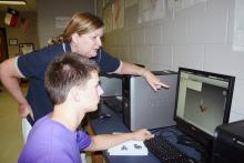 (ARCHIVE PHOTO | THE GRAHAM LEADER) Clark Miracle reverse engineers a small motor with a little help from his teacher Michelle Lowrey in May 2012. Miracle was part of the Project Lead the Way engineering curriculum and advanced to national competition in the Technology Student Association.