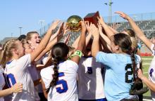 (THOMAS WALLNER | THE GRAHAM LEADER) The bi-district championship trophy is held high in the air as the Lady Blues celebrate their victory Thursday, March 19 over the Canyon Randall Lady Raiders. The next round for the Lady Blues was against the Lubbock-Cooper Lady Patriots in area.