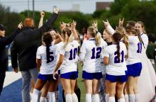 (THOMAS WALLNER | THE GRAHAM LEADER) Head coach Casey Weil, Assistant coach John Tuggle and the Lady Blues soccer team huddle up during the regional semifinal matchup with the Godley Ladycats. The Lady Blues fell 1-0 to the Ladycats, but were able to push farther into the playoffs than any other soccer team in school history.