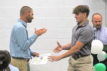 (ARCHIVE PHOTO | THE GRAHAM LEADER) Senior Ty Strawbridge shakes hands with coach James King as part of the football recognitions at the Newcastle sports banquet in May 2024. This year’s banquet will be held at 6 p.m. Friday, May 22 in the legacy gym.