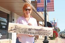 (THOMAS WALLNER | THE GRAHAM LEADER) Young County Museum of History and Culture Treasurer Shannon Plowman Potts holds a photo taken July 3, 1923. The organization is looking to recreate the photo with the community at 9:30 a.m. Tuesday, July 4 at the same location on the downtown square.