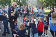 (THOMAS WALLNER | THE GRAHAM LEADER) Student Resource Officer Blake Davis speaks with children at the Week of the Young Child event Thursday, April 16 on the Graham downtown square.