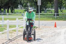 (ALEX HAVARDANSKY | THE GRAHAM LEADER) Dan Kieninger with Texas Cemetery Restoration performs a ground penetrating radar survey Monday, July 14 at the Oak Grove Colored-William P. Johnston Cemetery. The city of Graham gave the company access to the lot adjacent to the cemetery to conduct a GPR survey.
