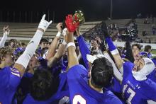 (TC GORDON | THE GRAHAM LEADER) The Graham Steers lift the area championship trophy over their heads Thursday, Nov. 21 following their 63-6 crushing of the Monahans Loboes.