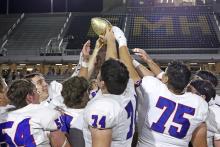 (TC GORDON | THE GRAHAM LEADER) The Graham Steers lift the district championship trophy above their heads in celebration Friday, Nov. 8 after the team beat the Eagle Mountain Knights 49-3.