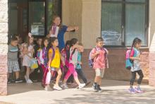 (FILE PHOTO | THE GRAHAM LEADER) A teacher at Pioneer Elementary School lets students out of the campus on the first day of school in 2019.