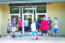 From left, Evan Ranger, Hayden Husen, Marcus Brooks, Garrett Gatlin, Marc Tate, Austin Bahl, Jake Holland and Sam Perkins listened while coach Marcus Morris stood next to his son, Conrad, and talked to his runners about running safely before cross country training began Monday.
