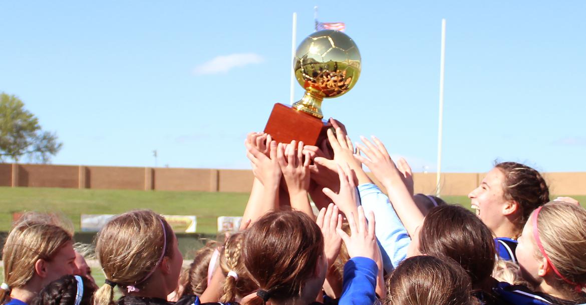 (TC GORDON | THE GRAHAM LEADER) The Lady Blues lift the bi-district trophy up and celebrate together after defeating Borger in a bi-district matchup. The win was the Lady Blues’ first playoff victory in the program’s history as they beat the Lady Bulldogs 4-3 in a penalty kick shootout.